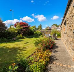 A garden with a pathway and furniture at Glen Lea in Giggleswick, Settle