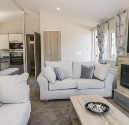 A living room with sofas cushions coffee table and wall mounted television at Parkers Place in Carnforth