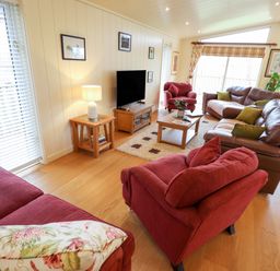 A living room with sofas chairs a television and coffee table at Tanqueray Lodge Kenwick near Louth