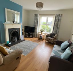 A living room with a fireplace and television at 4 The Cloisters in Bushmills, County Antrim