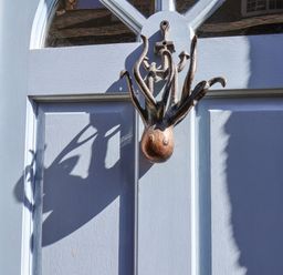 A blue wooden door with a metal octopus door knocker and an anchor decoration at Navigators Rest in Whitby