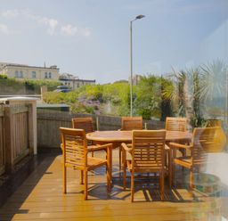 An outdoor dining area with wooden furniture at 11 Cove View Apartments Ilfracombe