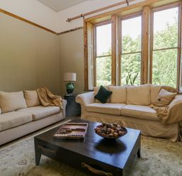 A living room with two sofas a coffee table and large windows at The Residence in Cleator