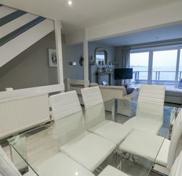 A dining room with glass table and chairs at White Sails Y Felinheli