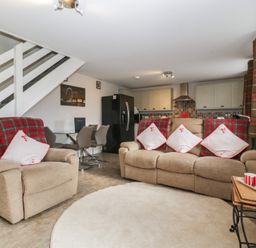 A living room with a sofa and dining area at Top Lodge in Llanvair-Discoed near Penhow