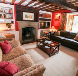 A sitting room with patterned sofas a leather couch a coffee table fireplace and bookshelves at Pentre Hall Bronygarth near Chirk