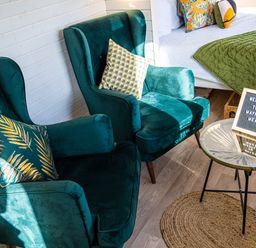 Two green armchairs with decorative pillows near a glass round table with a welcome sign at Veiko - Mayflower Meadow in Burshill near Brandesburton