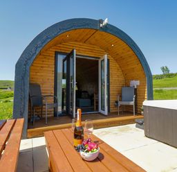 An outdoor area with a wooden pod structure and seating at Beech in Ulverston