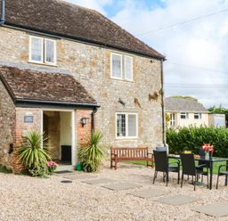 A house with a patio area and seating at The Abbey Grange near Charmouth