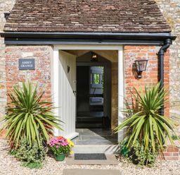 An entrance with plants and a sign at Abbey Grange near Charmouth