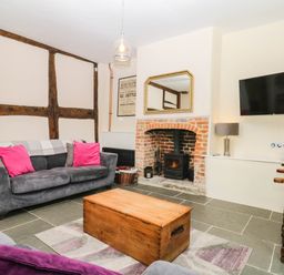 A living room with a fireplace and sofa at The Abbey Grange near Charmouth