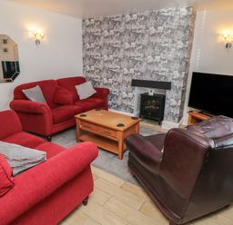 A living room with sofas and a television at Bluebell Cottage in Flamborough