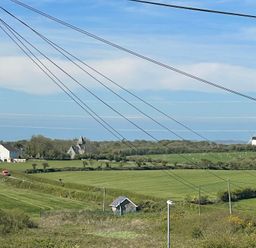 A landscape view with fields and a windmill at 11 Penygroes in Llanddeusant