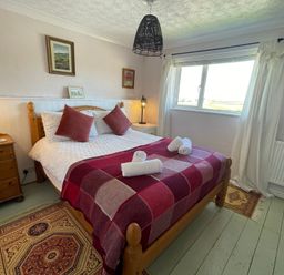 A bedroom with a double bed and furniture at 11 Penygroes in Llanddeusant