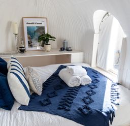 A bedroom with a neatly made bed blue and white pillows and rolled towels on a bed cover at Andrus - Mayflower Meadow in Brandesburton