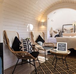A seating area with two wicker chairs and a table with a welcome sign next to a bedroom at Indrek - Mayflower Meadow in Brandesburton