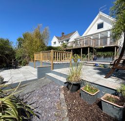 A multi level garden with patio areas plants and wooden railing at Old Orchard in Saundersfoot