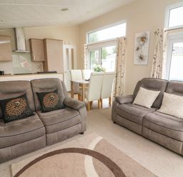 A living room with two sofas and a dining table with chairs at Waterside Lodge South Lakeland Leisure Village near Carnforth