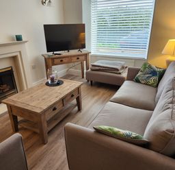 A living room with a sofa and television at 8 Arvonia Terrace Cricieth