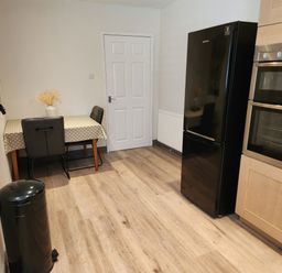 A kitchen with a table and chairs and appliances at 8 Arvonia Terrace Cricieth