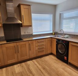 A kitchen with cabinets, sink, and washing machine at 8 Arvonia Terrace Cricieth