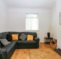 A living room with a sofa and decorative items at Y Berth in Caernarfon