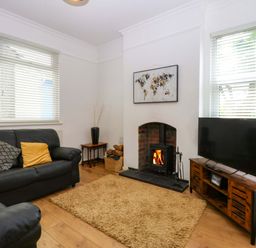 A living room with a fireplace and television at Y Berth in Caernarfon