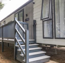 The exterior of a lodge with steps and a railing leading to the entrance at Finch 59 in Cayton