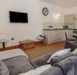 A living room with a kitchen area at Swallows Retreat in Tenby