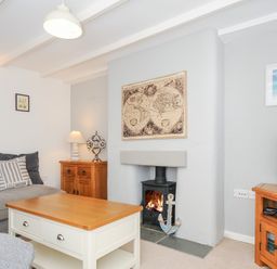 A living room with a fireplace a sofa a coffee table and a television at Quay House in Charlestown