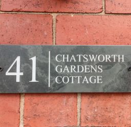 A house number plaque reading 41 Chatsworth Gardens Cottage on a brick wall at 41 Chatsworth Gardens in Scarborough