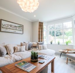 A living room with a sofa an armchair a wooden coffee table and plants on the window at 41 Chatsworth Gardens in Scarborough