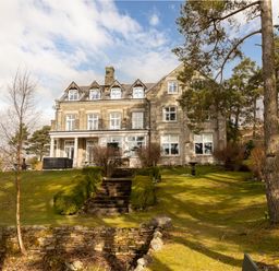 A stone house with multiple windows and a garden with stairs and trees at Heatherbrae in Middleton-In-Teesdale