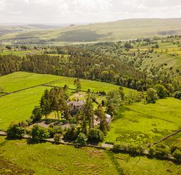 A rural landscape with fields trees and a house at Heatherbrae in Middleton-In-Teesdale