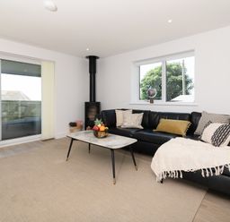 A living room with a sofa and coffee table at Sandy Cove in Praa Sands