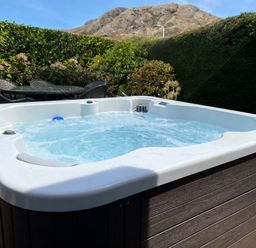 A hot tub with water and outdoor furniture at Holme Fell in Coniston