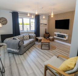 A living room with a sofa and coffee table at Ty Glan Morfa in Morfa Bychan