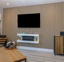 A living room with a television and fireplace at Ty Glan Morfa in Morfa Bychan