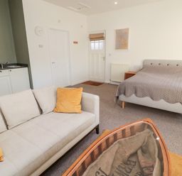 A studio apartment with a sofa and bed near a kitchenette at Cheviot View in Crookham near Cornhill-On-Tweed