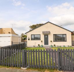 A single-story house with beige walls and a gray picket fence at Valley Pines in Valley