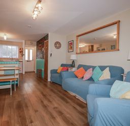 A living room with sofas and a table at Kippy Cottage in Porthtowan