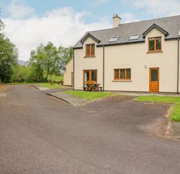 A semi detached house with a driveway and grass at 14 Sneem Leisure Village in Sneem County Kerry