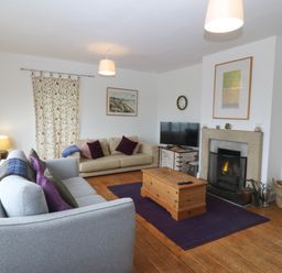 A living room with sofas and a fireplace at Faraway in Rhosneigr