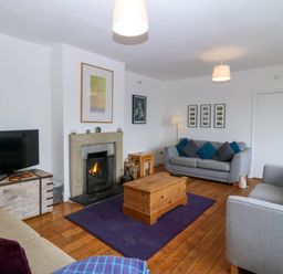 A living room with a fireplace and sofas at Faraway in Rhosneigr
