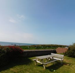 A table and benches by the ocean at Faraway in Rhosneigr