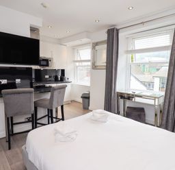A studio room with a kitchen area and a bed at Bowness Central in Bowness-On-Windermere
