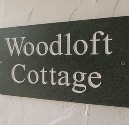 A sign displaying Woodloft Cottage at Woodloft Cottage Elterwater near Chapel Stile