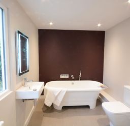 A bathroom with a bathtub a sink a toilet and a window at Durdans Walberswick in Walberswick