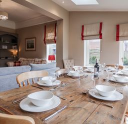 A dining room with a table set for dinner at Holly Lodge in Aldeburgh
