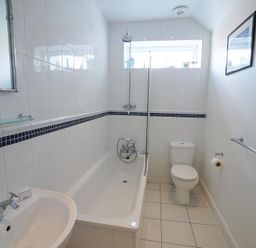 A bathroom with a bathtub shower toilet and sink at The Hideaway in Aldeburgh